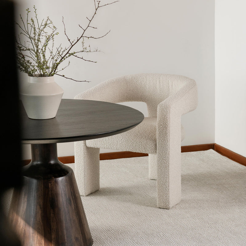 Round dark wood dining table with smooth tabletop and central pedestal