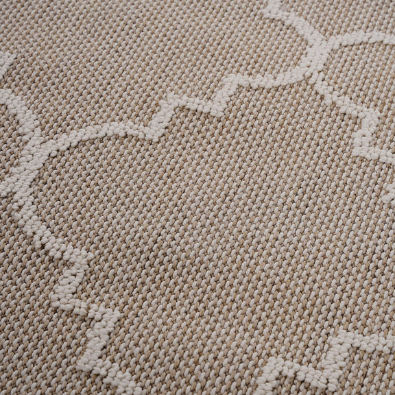 Beige textured rug surface with raised trellis pattern in a soft loop weave.