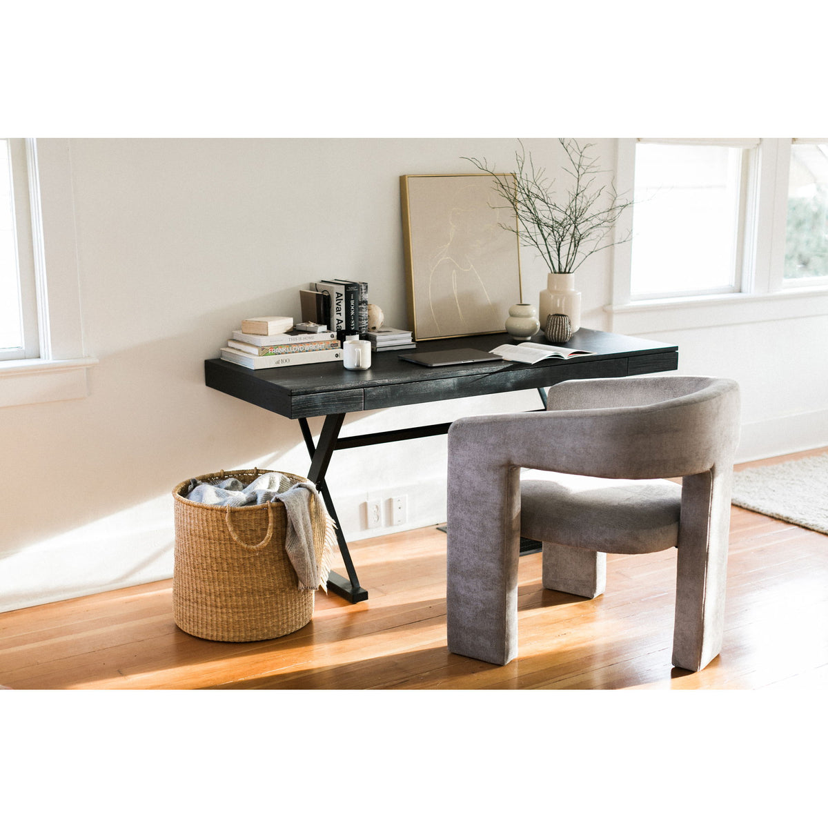 Black ash desk with tabletop items and X-frame legs