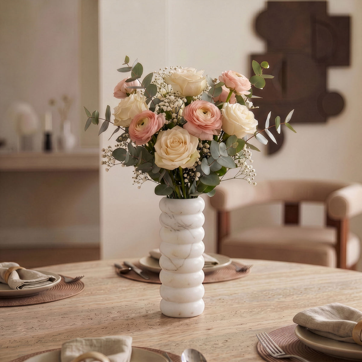 White marble vase with bouquet of flowers centerpiece on a dining table