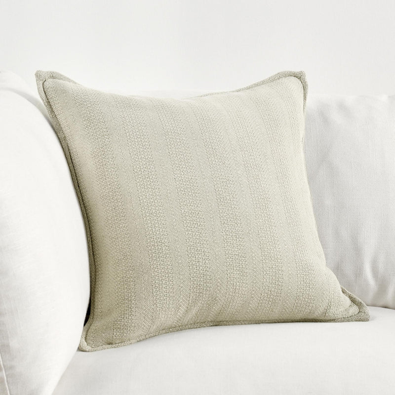 Natural textured throw pillow on sofa with piped edges, square