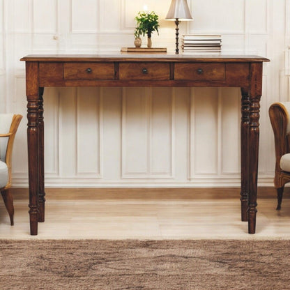 Dark brown console table with turned legs and three drawers with round knobs