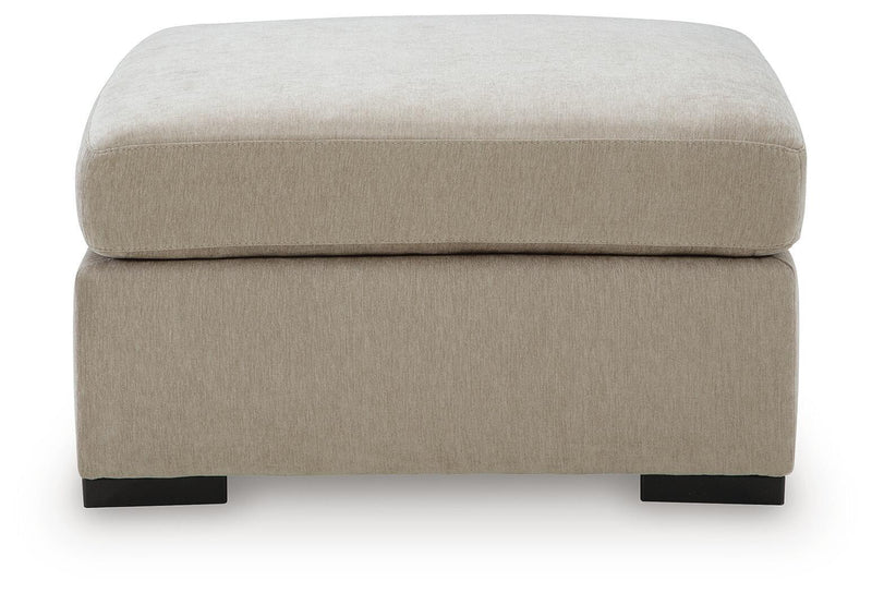 Oversized accent ottoman in light neutral upholstery with rounded top and black legs