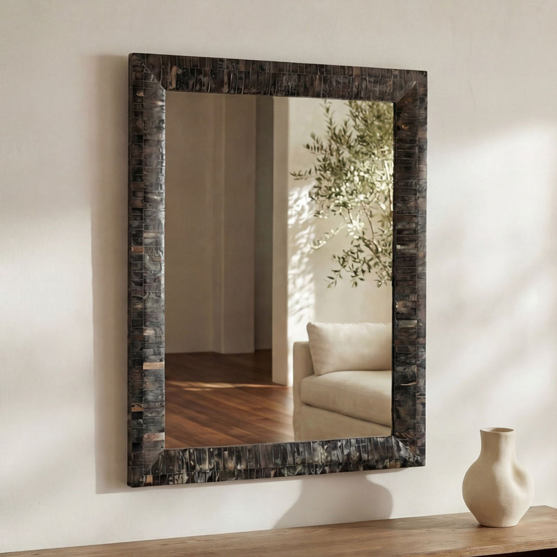 Wall mirror with horn inlay frame and multicolor border, reflecting interior seating