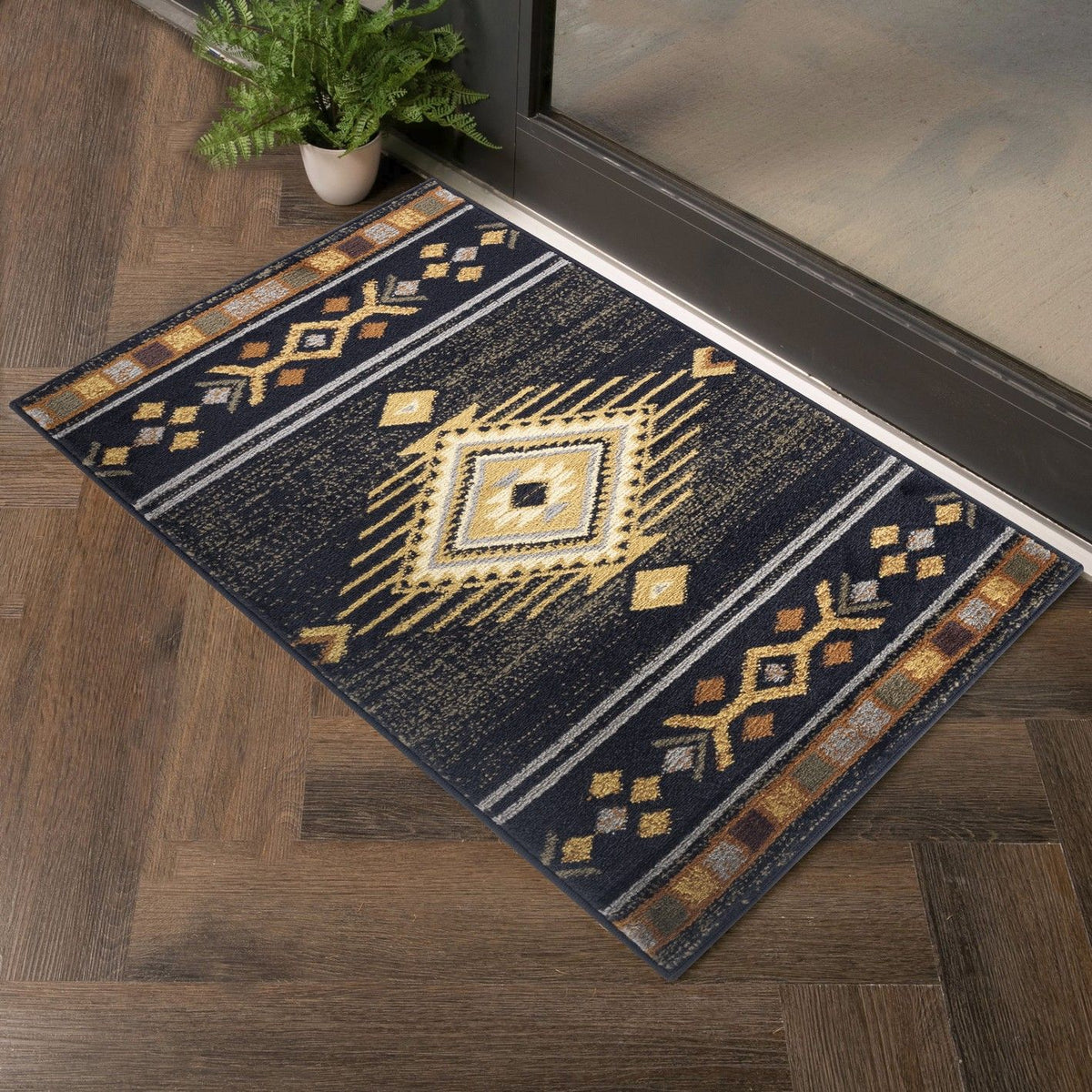 Black southwest area rug with yellow medallion center and geometric stripe border.