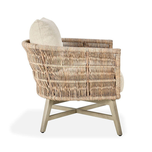 Outdoor accent chair side view with woven rattan arms and sand seat cushion