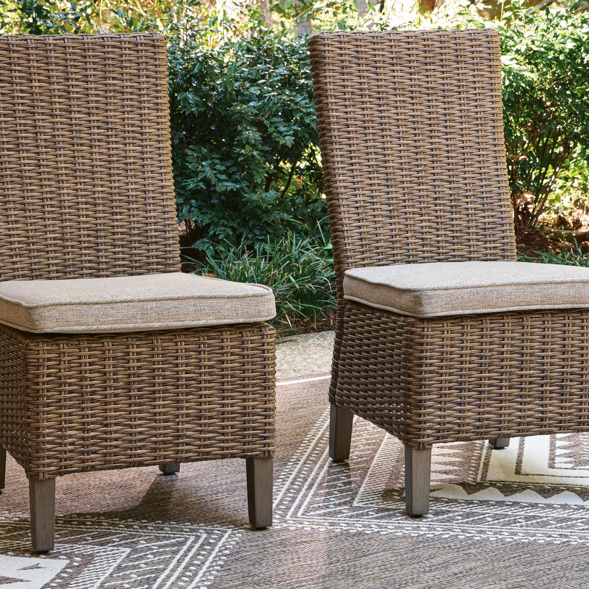 Pair of beige woven side chairs with light beige cushions on dark legs