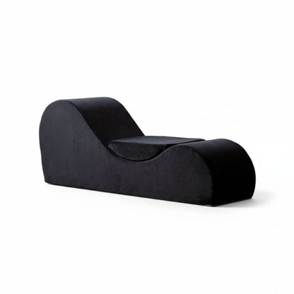 Two-tone chaise lounge chair with curved backrest and thick dark upholstery cushions