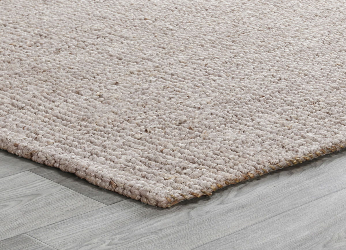 Beige chunky loop rug corner showing dense loop pile and low flat weave