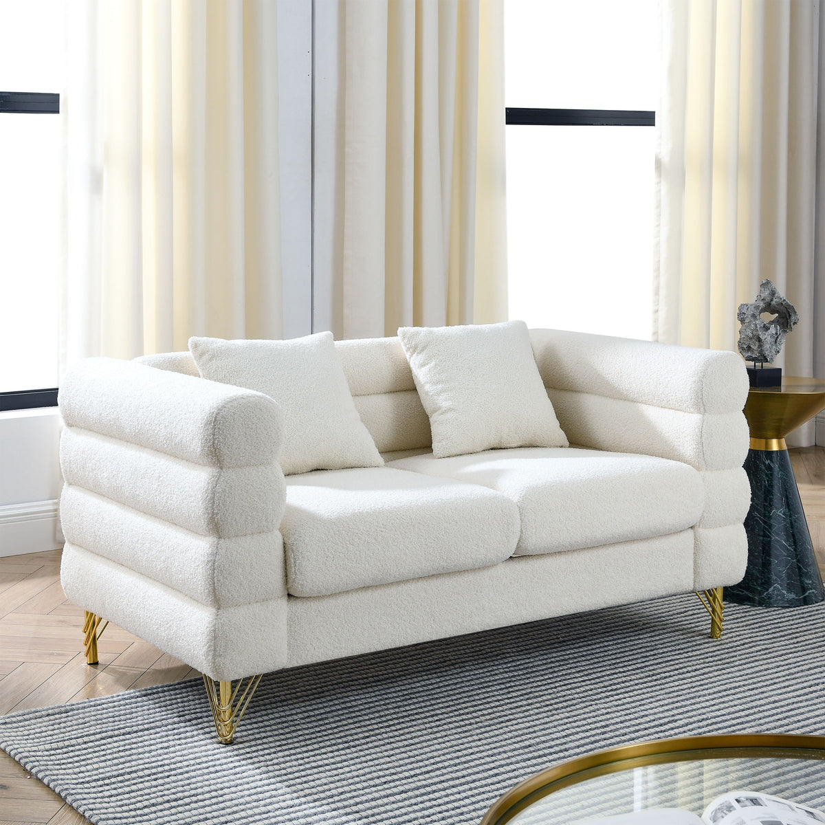 Beige sectional sofa with rounded arms, tufted cushions, and gold metal legs
