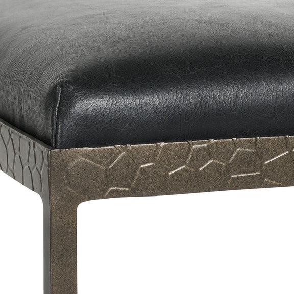 Leather counter stool with black cushioned seat and dark metal base with textured pattern
