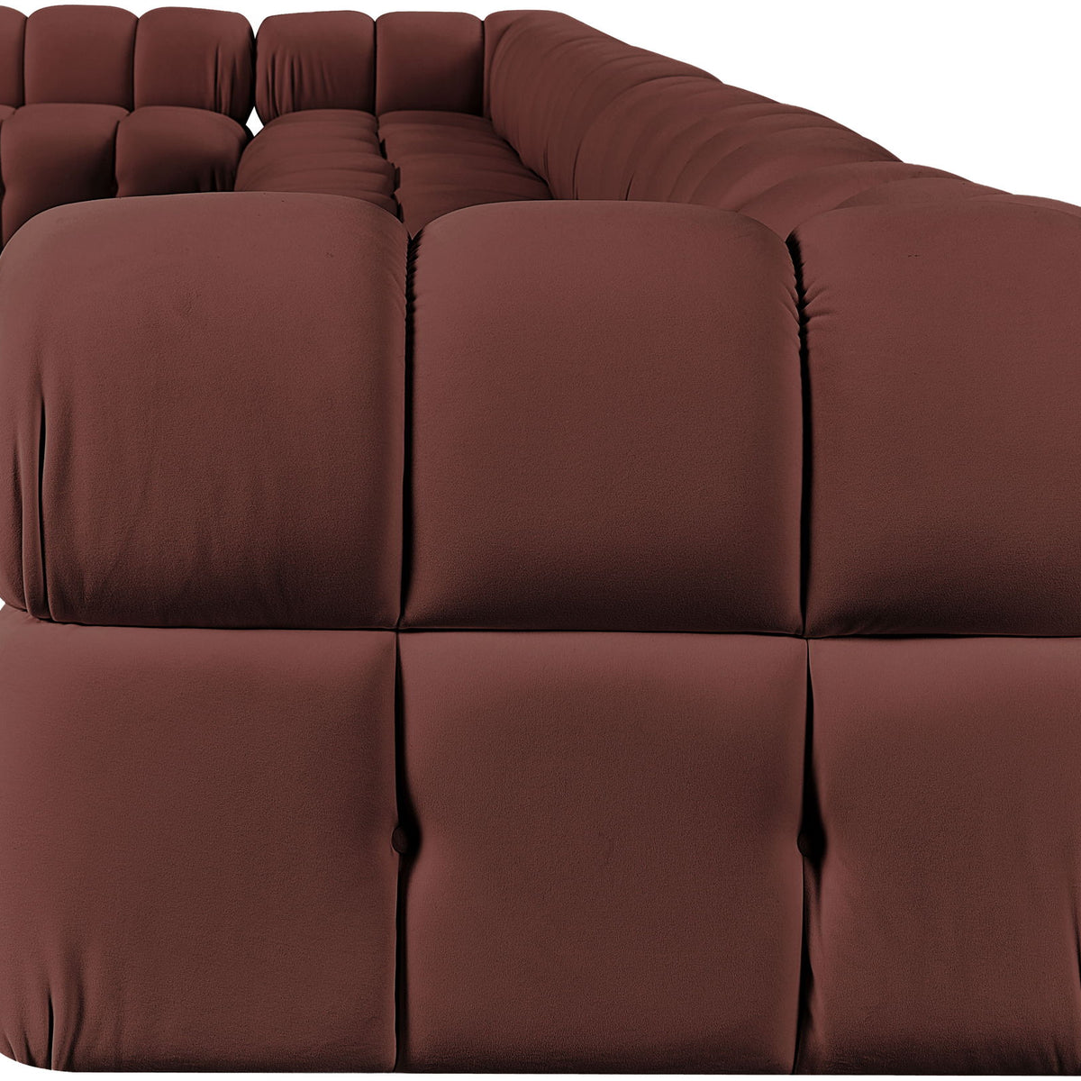 Dark red velvet L-shaped sectional sofa with tufted cushions and rounded arms.