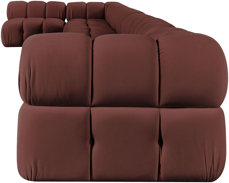Dark red velvet L-shaped sectional sofa with tufted cushions and rounded arms.