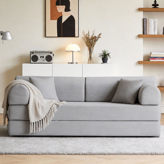 Light gray convertible sleeper sofa bed with three back cushions and a throw blanket