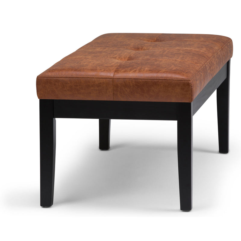 Tufted ottoman bench in medium brown faux leather with black legs